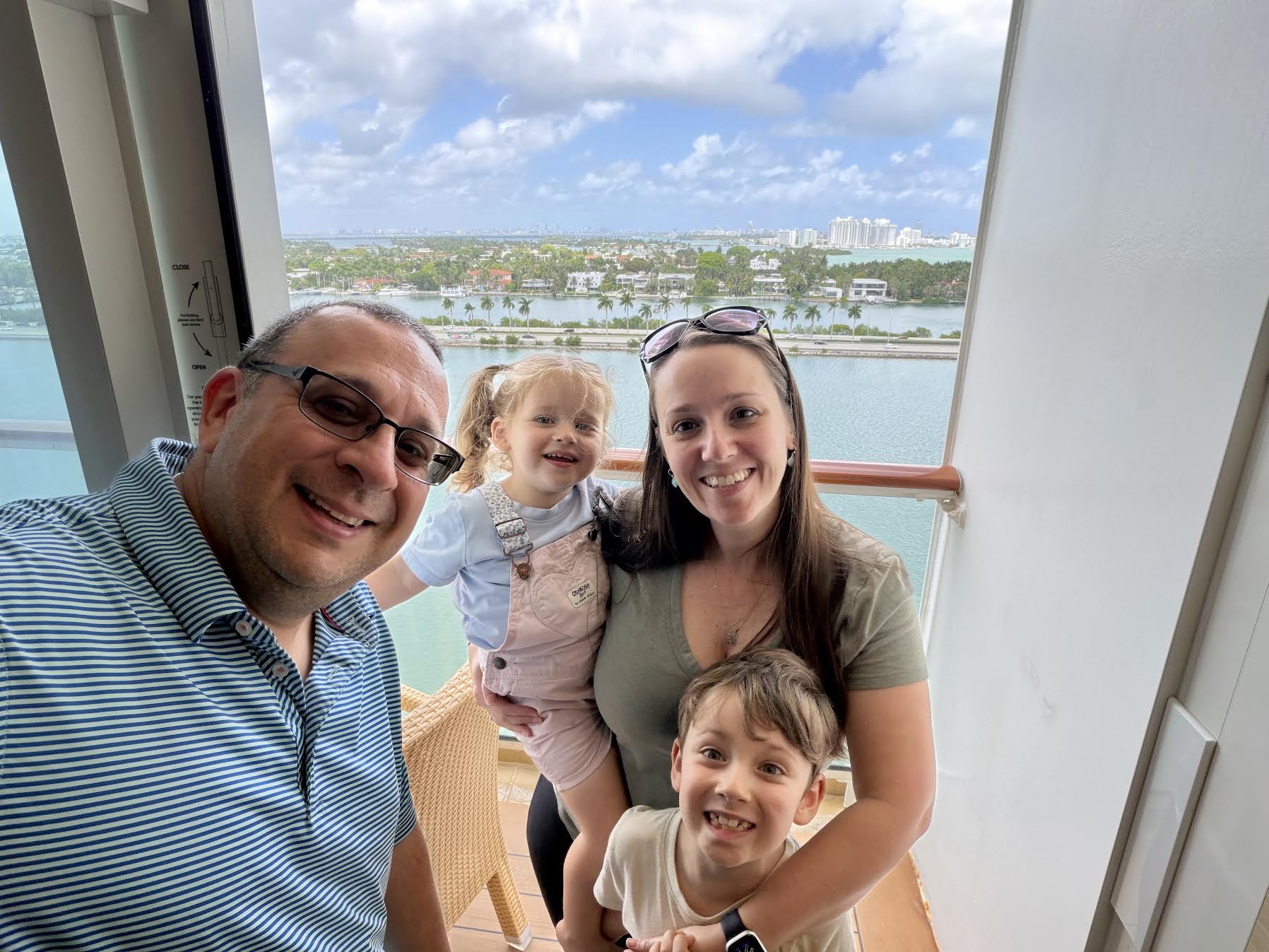 Aaron and his family enjoying a cruise together on their balcony with Miami in the background